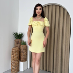 فستان قصير باللون الاصفر الفاتح مع أكمام منتفخة ورباطات متقاطعة على الظهر