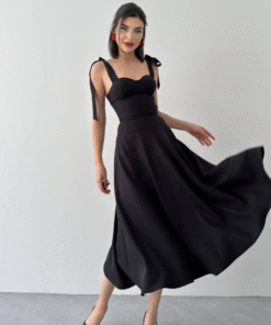 فستان أسود يتميز بحمالات كتف يمكن ربطها على شكل عقد